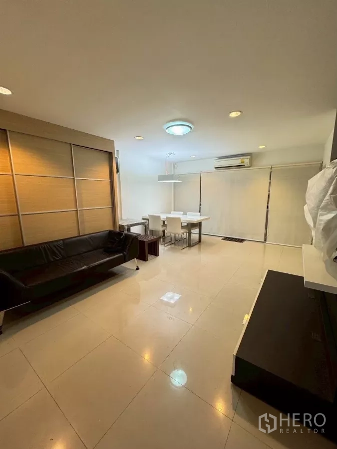 ทาวน์เฮาส์ ให้เช่าในSuan Luang, Bangkok - ห้องนั่งเล่นกว้าง พื้นกระเบื้องเงา โซฟาและชุดทานข้าว พร้อมม่านม้วน