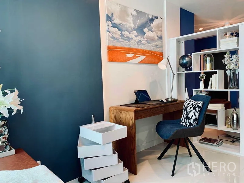 คอนโด ให้เช่าในWatthana, Bangkok - มุมทำงานกะทัดรัด โต๊ะไม้ เก้าอี้สีน้ำเงิน และชั้นโชว์แบบเปิด