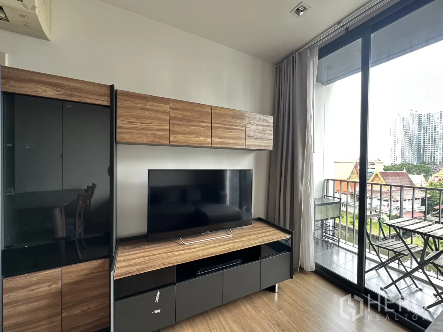 คอนโด for rent in Watthana, Bangkok - ห้องนั่งเล่นมีชั้นวางทีวีและประตูกระจกสไลด์ออกสู่ระเบียง