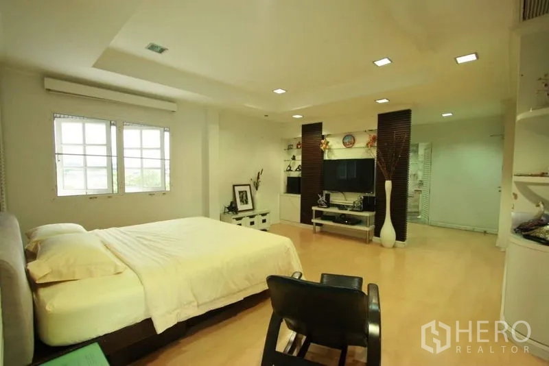 Detached House for rent in Bang Phli, Samut Prakan - Expansive master bedroom with entertainment wall, built-in shelving and light wood floors.