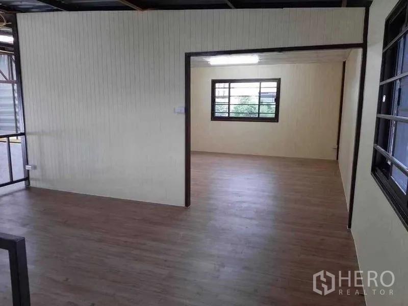 Warehouse for rent in Prawet, Bangkok - Airy office space with wood-look floors, large windows and fluorescent lighting.