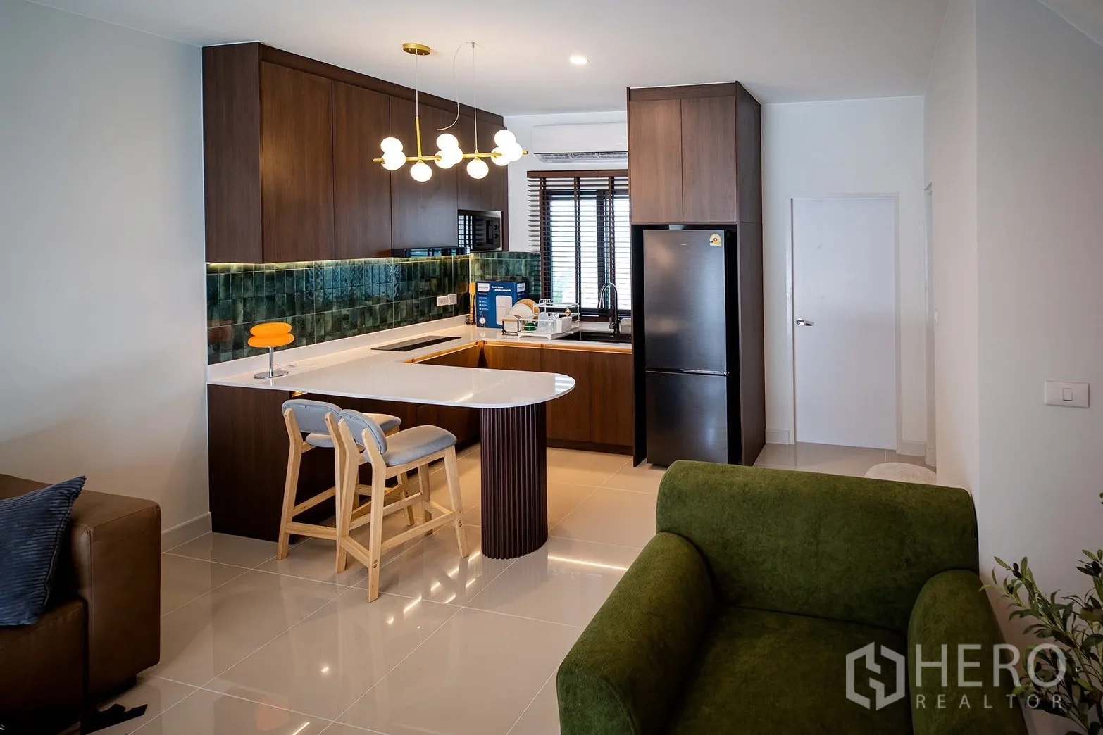 联排别墅 for rent in Bang Phli, Samut Prakan - 带早餐吧台的厨房，吊灯与深色木柜。