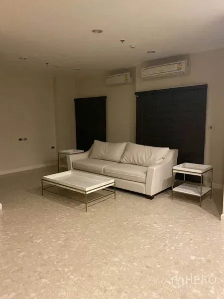 คอนโด ให้เช่าในKhlong Toei, Bangkok - ห้องนั่งเล่นมินิมอล โซฟาสีขาว โต๊ะข้าง พื้นกระเบื้อง และแอร์แขวนผนังสองเครื่อง