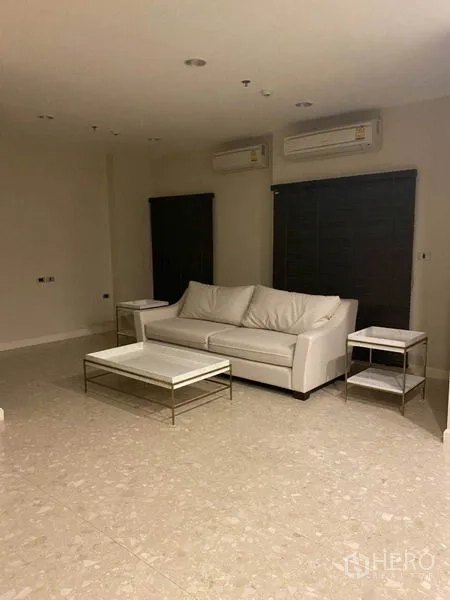 คอนโด ให้เช่าในKhlong Toei, Bangkok - ห้องนั่งเล่นมินิมอล โซฟาสีขาว โต๊ะข้าง พื้นกระเบื้อง และแอร์แขวนผนังสองเครื่อง