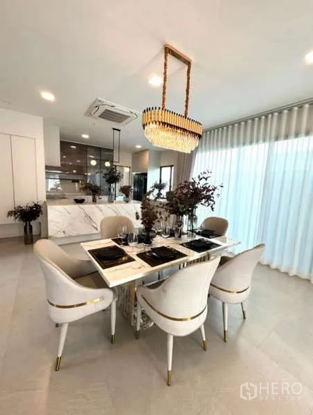 Detached House for rent in Samut Prakan - Open dining area facing a modern kitchen with marble island.