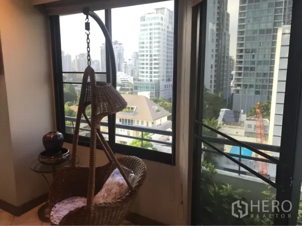 คอนโด ให้เช่าหรือขายในWatthana, Bangkok - มุมพักผ่อนมีเก้าอี้แขวนหวายข้างหน้าต่างกว้าง ชมวิวเมืองและต้นไม้ด้านนอก