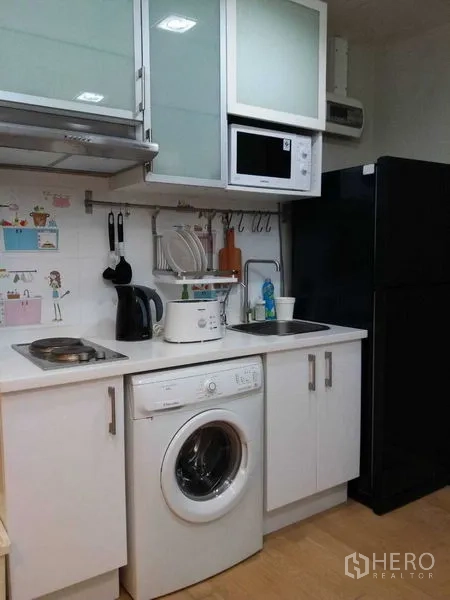 คอนโด ขายในWatthana, Bangkok - ครัวขนาดกะทัดรัด มีเตา ไมโครเวฟ ตู้เย็น และเครื่องซักผ้าในห้อง.