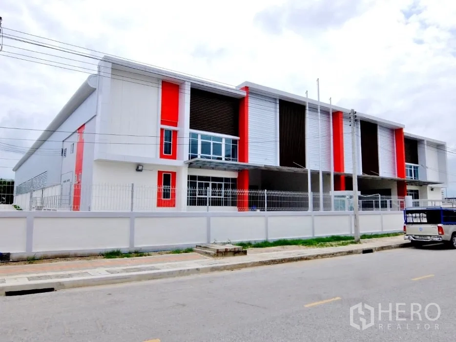 工厂 出租在Bang Sao Thong, Samut Prakan - 工业建筑正立面，红色点缀、围栏与车道。