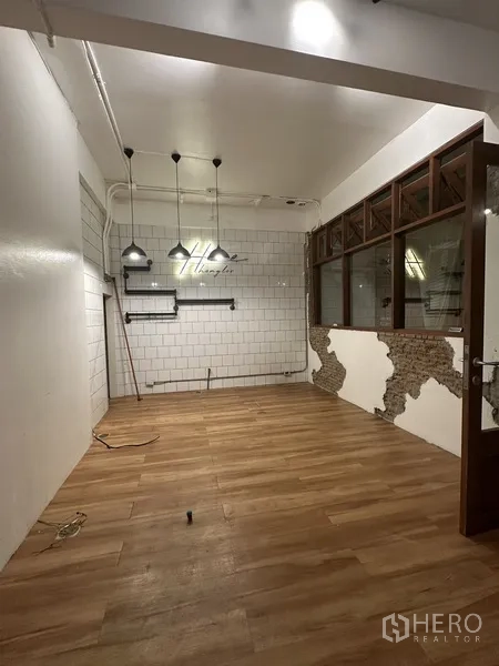 带办公室的家 出租在Watthana, Bangkok - 长形办公区，木地板、玻璃隔断与装饰墙面。