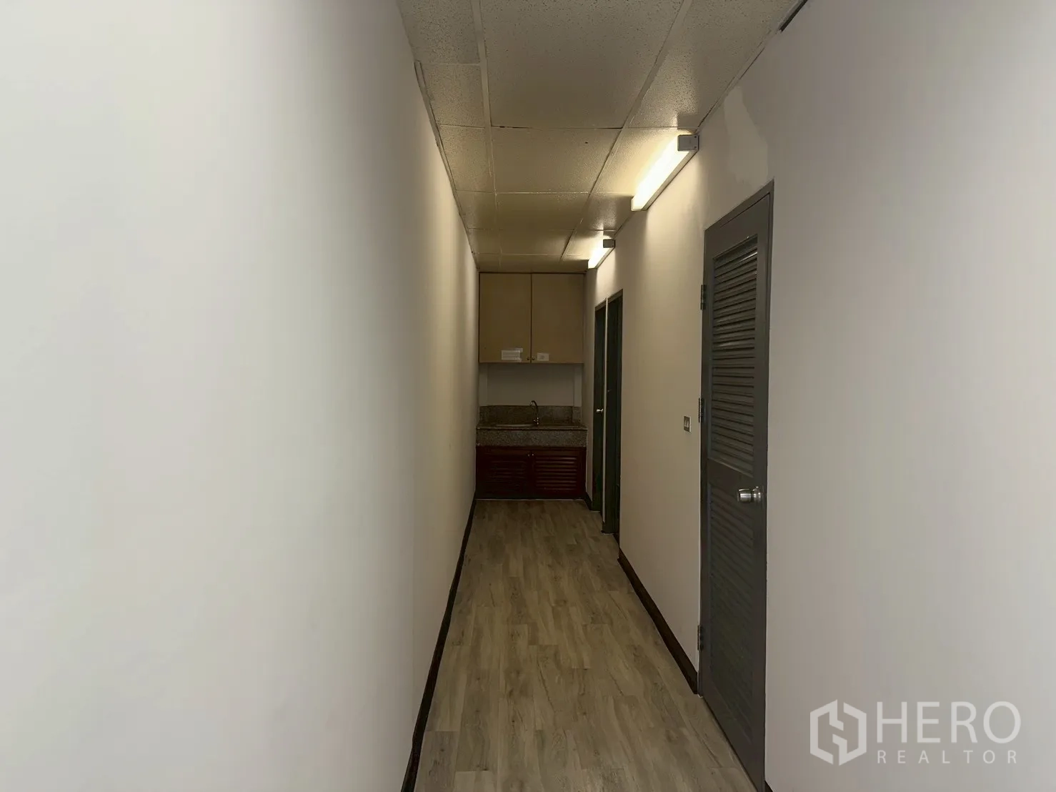 Office Space for rent - Internal hallway with built-in pantry sink and overhead cabinets.
