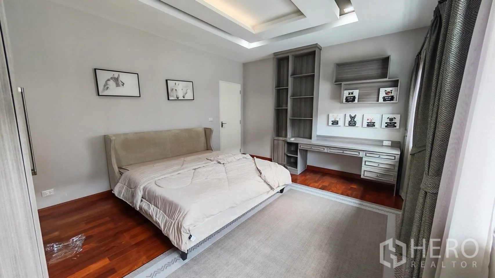 Detached House for rent or sale in Bang Phli, Samut Prakan - Second bedroom with grey built-in shelves and a study desk beside an upholstered bed.