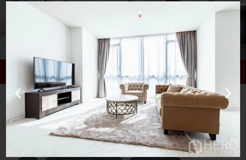 คอนโด ให้เช่าหรือขายในWatthana, Bangkok - ห้องนั่งเล่นรับแสงเต็มที่ ผ้าม่านทึบ-โปร่ง ทีวี และโซฟาสีเบจ