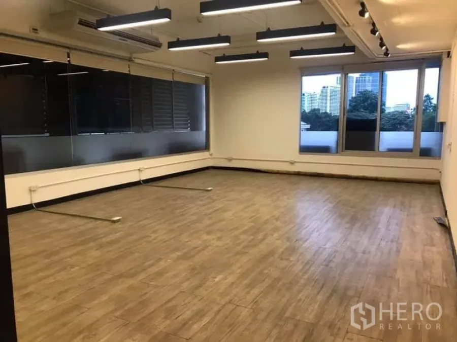 สำนักงาน ให้เช่าในKhlong Toei, Bangkok - มุมสำนักงานพร้อมหน้าต่างกว้าง วิวเมือง พื้นลายไม้ และไฟเส้นแบบแขวน