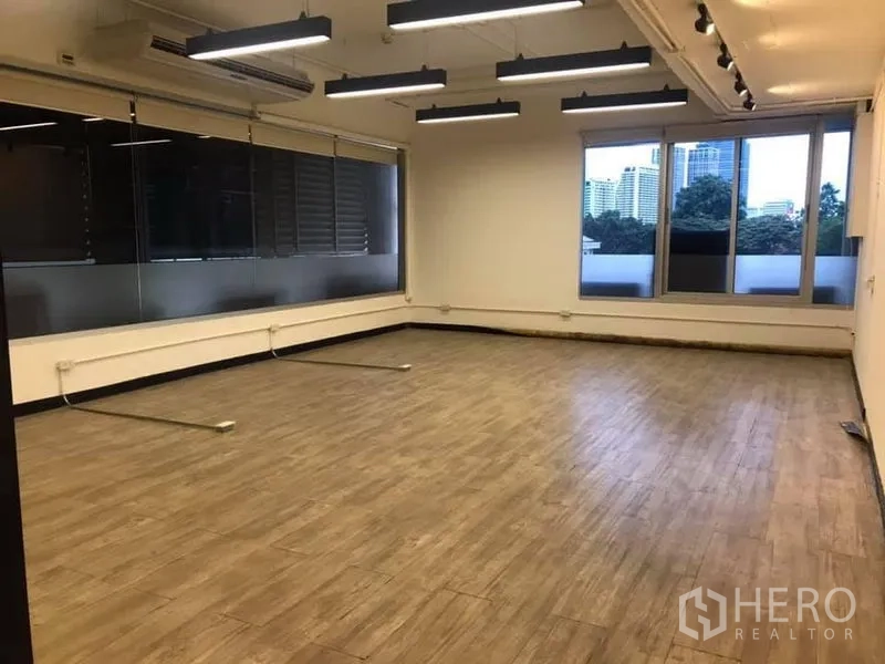 สำนักงาน ให้เช่าในKhlong Toei, Bangkok - มุมสำนักงานพร้อมหน้าต่างกว้าง วิวเมือง พื้นลายไม้ และไฟเส้นแบบแขวน
