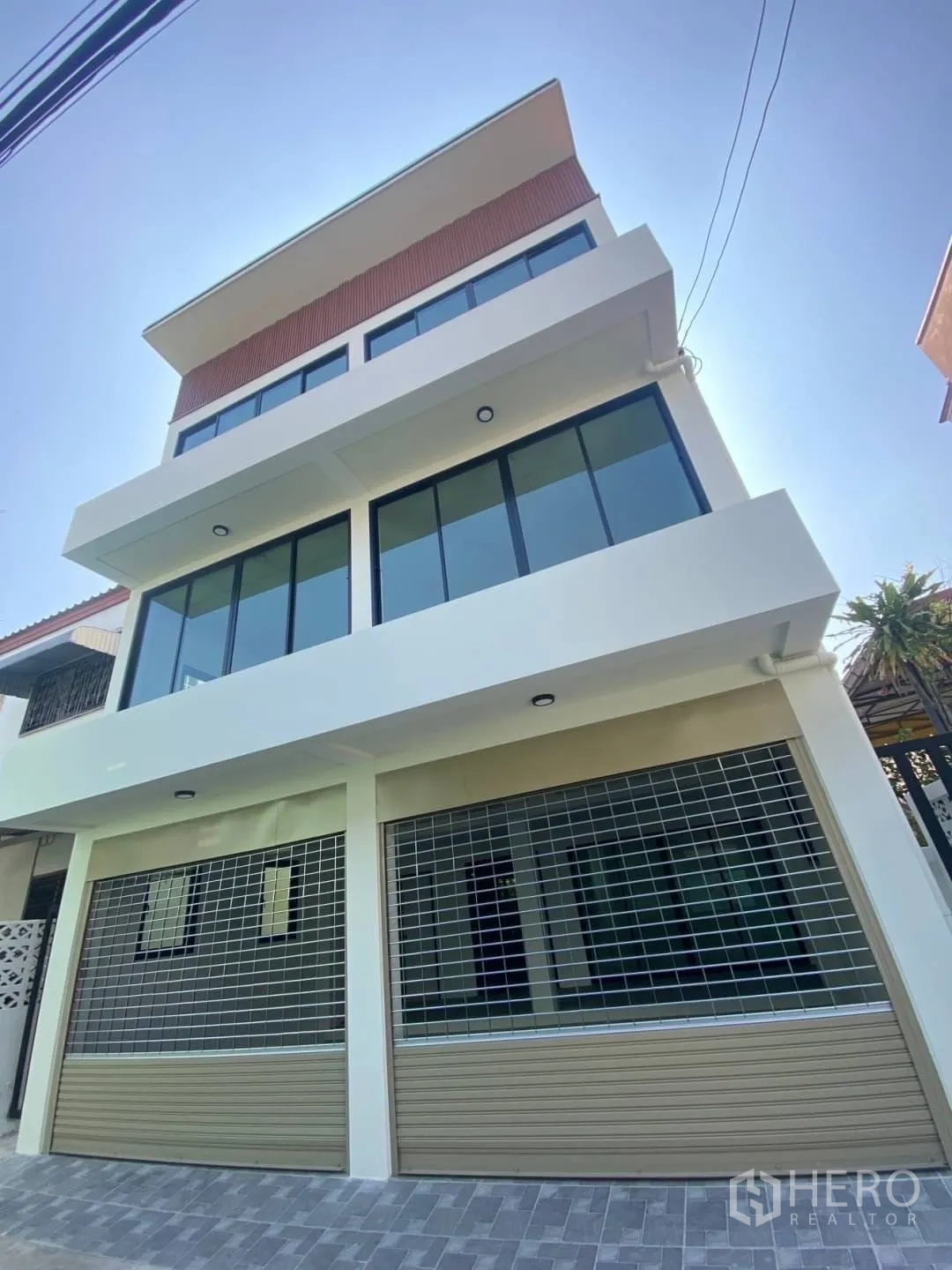 Home Office for sale - Modern multi-storey home office facade with wide windows and dual roller shutters in Watthana, Bangkok.