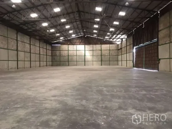 工厂 出租在Bang Pakong, Chachoengsao - 面向大型滑动门的厂房空间，桁架屋顶与天窗。