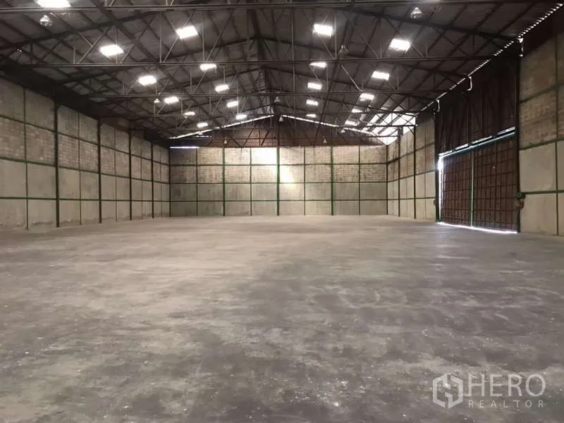 工厂 出租在Bang Pakong, Chachoengsao - 面向大型滑动门的厂房空间，桁架屋顶与天窗。
