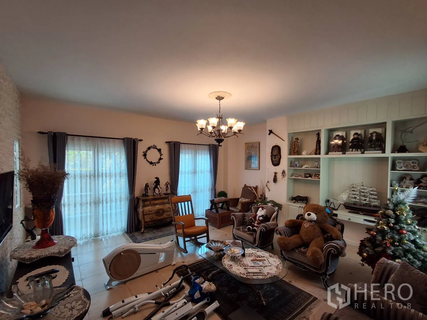 Detached House for rent or sale in Ban Chang, Rayong - Living room with built-in shelving, armchairs, coffee table and large windows.