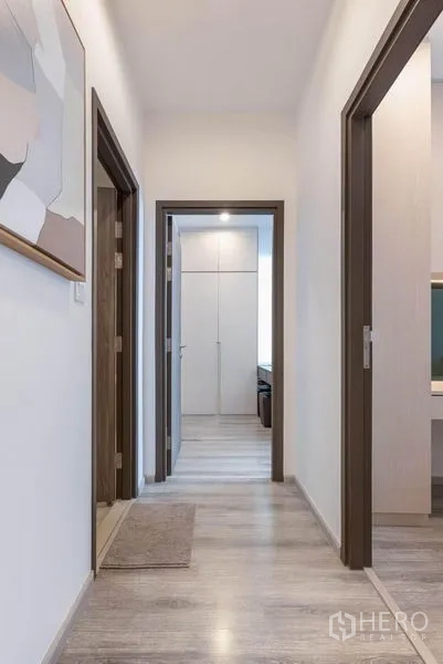 Condominium for rent in Bang Na, Bangkok - Clean hallway with wood flooring leading to bedrooms and bathroom.