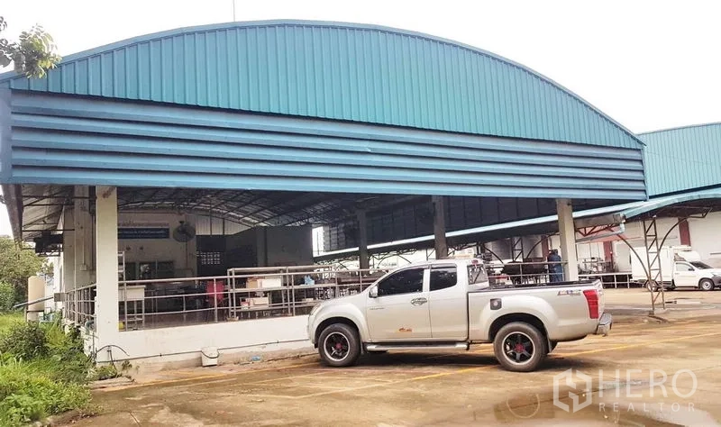 โรงงาน ขายในLam Luk Ka, Pathum Thani - มุมมองอาคารหลังคาโค้งและช่องจอดรถขีดเส้นชัดเจนข้างตัวโรงงาน