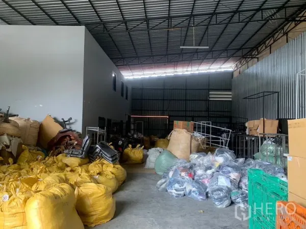 Warehouse for rent in Bang Kapi, Bangkok - Spacious warehouse interior with high ceiling, steel trusses and open concrete floor for storage.