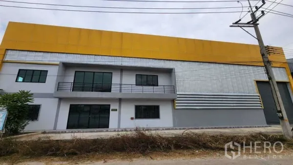 货栈 出租在Ban Phaeo, Samut Sakhon - 仓库外立面现代感十足，黄色围护板、两层办公区与卷帘门。