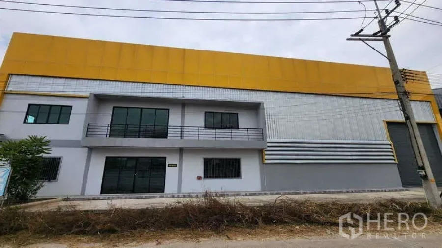 货栈 出租在Ban Phaeo, Samut Sakhon - 仓库外立面现代感十足，黄色围护板、两层办公区与卷帘门。