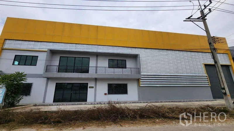 货栈 出租在Ban Phaeo, Samut Sakhon - 仓库外立面现代感十足，黄色围护板、两层办公区与卷帘门。