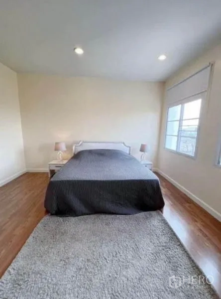 ทาวน์เฮาส์ ให้เช่าในPhra Khanong, Bangkok - ห้องนอนมาสเตอร์กว้าง ชุดเครื่องนอนสีเข้ม โต๊ะข้าง พรม และหน้าต่างสว่าง