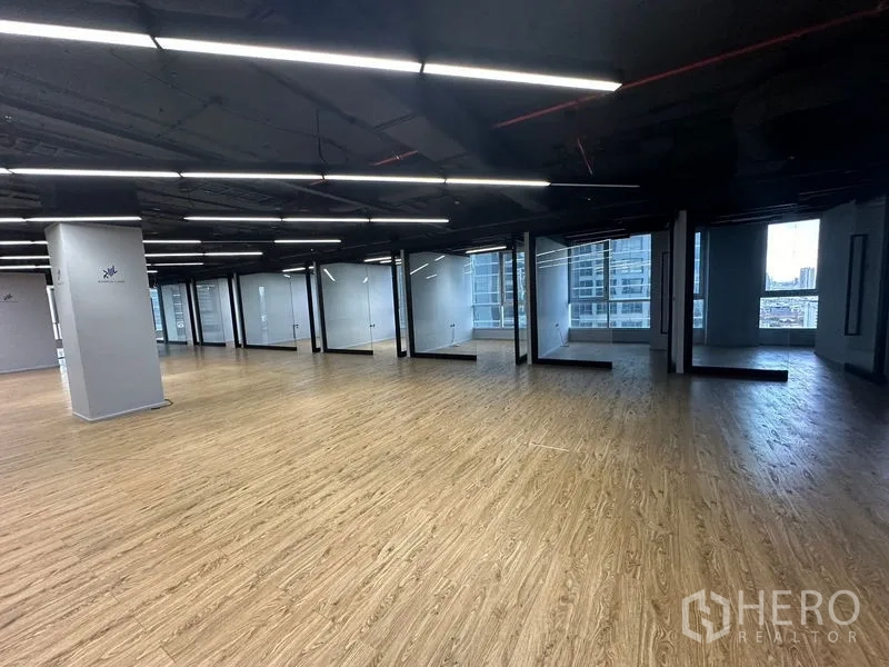 Office Space for rent in Bang Rak, Bangkok - Open-plan office lined with glass-partitioned rooms and city-facing windows.