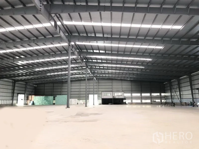 โรงงาน ให้เช่าในBang Phli, Samut Prakan - มุมมองภายในโกดังแบบกว้าง เห็นเสาเหล็กกลางอาคารและบล็อกสำนักงานด้านหลัง