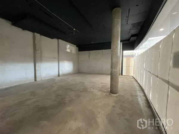 零售空间 出租 - 开阔的开放式区域，带结构柱与长弧形玻璃立面，适合自主装修。