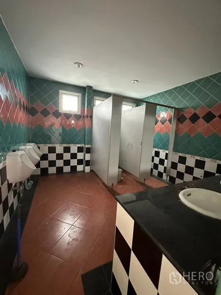 Showroom for rent or sale in Lam Luk Ka, Pathum Thani - Restroom with colorful wall tiles and separate stalls.