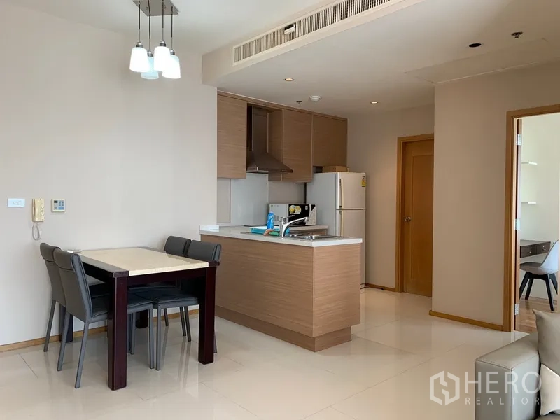 公寓 出租在Khlong Toei, Bangkok - 开放式厨房，设有岛台、吊柜与四人餐桌，现代简洁。
