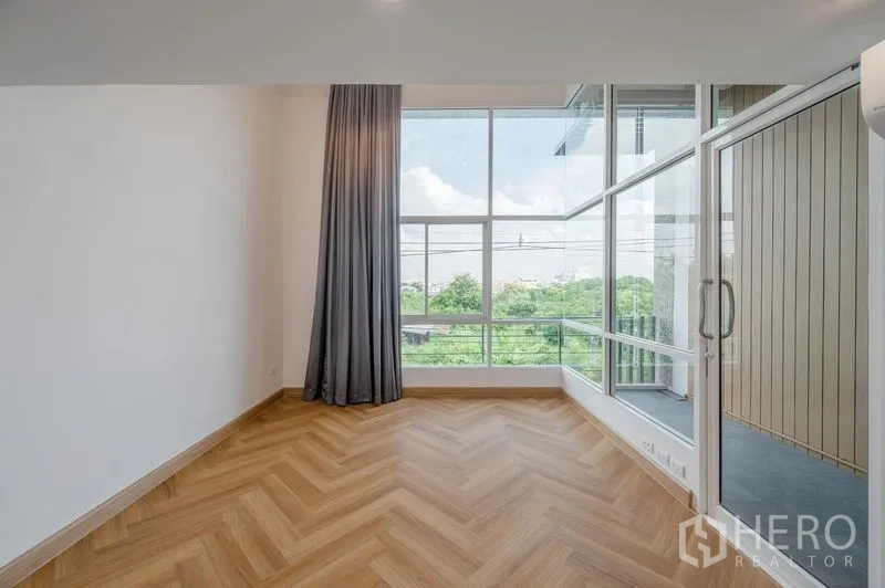 ทาวน์เฮาส์ ขายในLat Phrao, Bangkok - ห้องนอนกระจกเต็มผนัง มีผ้าม่านและประตูออกระเบียงวิวสีเขียว