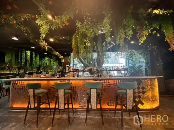 零售空间 出租在Watthana, Bangkok - 前厅吧台，马赛克立面、吊灯与热带风装饰。