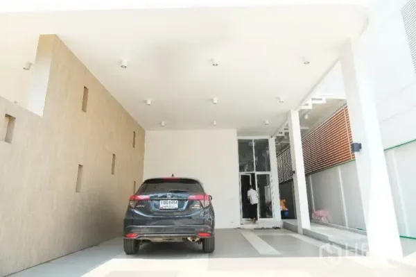 Home Office for rent or sale in Prawet, Bangkok - Covered ground-floor carport with ceiling lights and tiled accent wall at a modern home office.