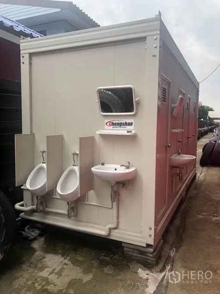 Warehouse for rent in Khlong Luang, Pathum Thani - Portable restroom unit beside the warehouse with sinks and urinals.