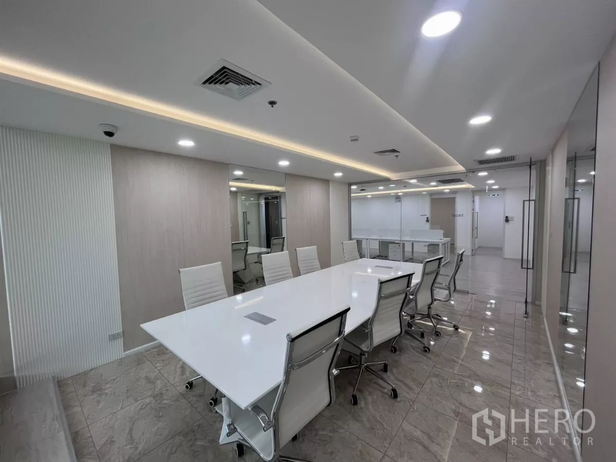 办公空间 for rent in Din Daeng, Bangkok - 会议室配白色长桌、旋转椅，玻璃墙连接开放办公区。