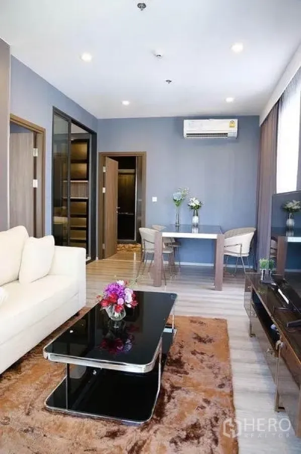 คอนโด ให้เช่าในHuai Khwang, Bangkok - โถงนั่งเล่น–รับประทานอาหารแบบเปิดโล่ง โซฟา โต๊ะกลางกระจกดำ ทีวี และพรม