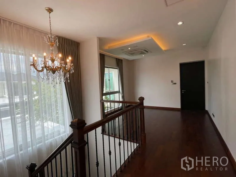 บ้าน ให้เช่าหรือขายในLat Krabang, Bangkok - โถงชั้นบนพื้นไม้ พร้อมแชนเดอเลียร์ และไฟฝ้าซ่อน