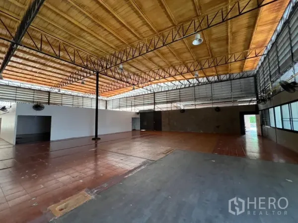 Warehouse for rent in Saphan Sung, Bangkok - Open-plan warehouse hall showing steel beams, louver windows and large floor area.