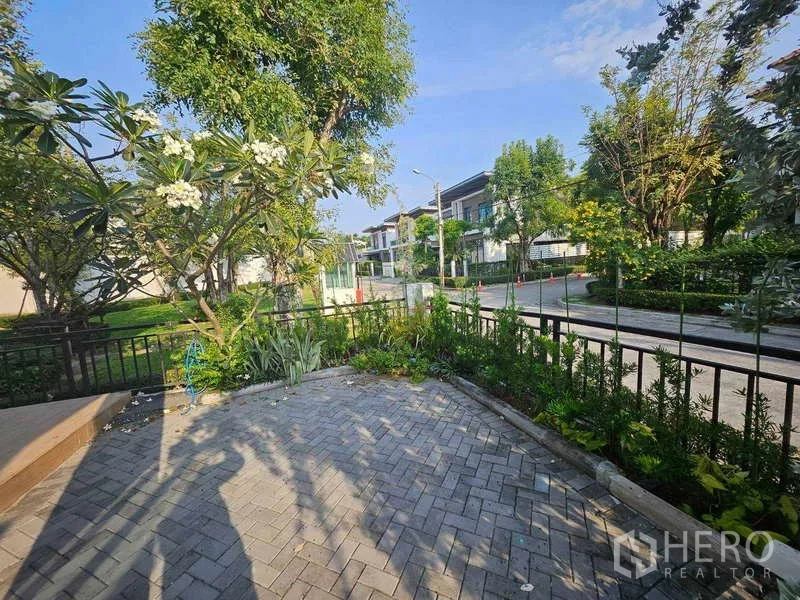 Detached House for rent in Saphan Sung, Bangkok - Front garden with paved patio, planting beds and a quiet tree‑lined street outlook.
