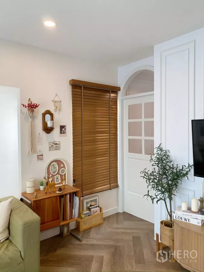 独立式住宅 出售在Sai Mai, Bangkok - 客厅一角，木百叶、置物架与家居饰品。