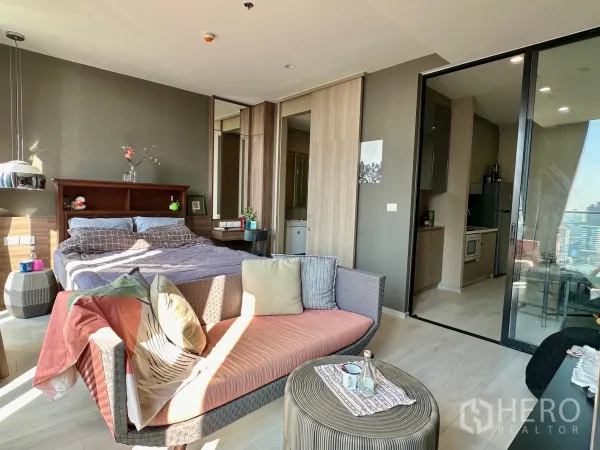 คอนโด ให้เช่าในPathum Wan, Bangkok - มุมเตียงนอนพร้อมโซฟา และประตูกระจกบานเลื่อนไปยังครัวแยก