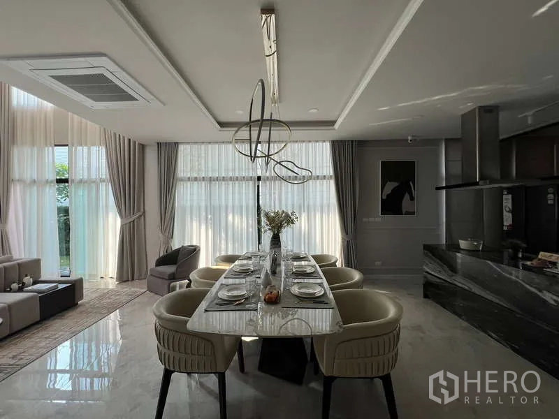 Detached House for sale in Suan Luang, Bangkok - Open-plan dining beside kitchen with sculptural light and tall drapes