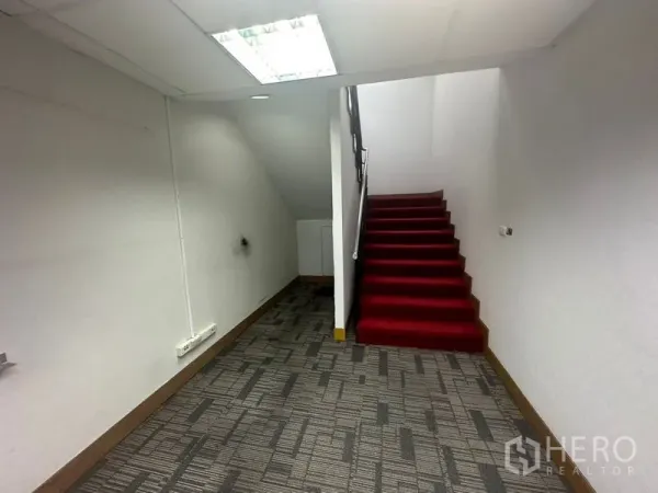 สำนักงาน ให้เช่าในKhlong Toei, Bangkok - บันไดภายในปูพรมสีแดงในโถงสำนักงาน ผนังสีขาวและพื้นพรม