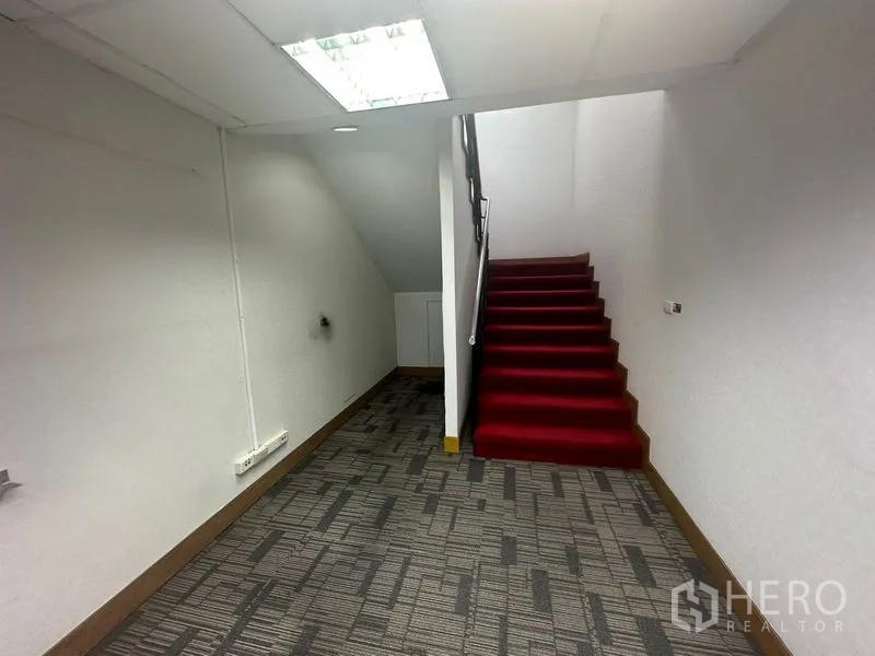 สำนักงาน ให้เช่าในKhlong Toei, Bangkok - บันไดภายในปูพรมสีแดงในโถงสำนักงาน ผนังสีขาวและพื้นพรม