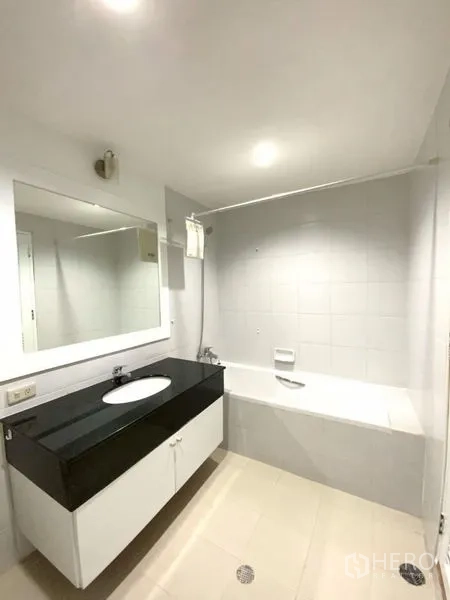 คอนโด ให้เช่าในWatthana, Bangkok - ห้องน้ำสะอาด กระจกบานใหญ่ เคาน์เตอร์ท็อปสีดำ และอ่างอาบน้ำพร้อมฝักบัว