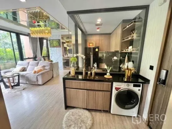 คอนโด ขายในWatthana, Bangkok - มุมนั่งเล่นเชื่อมครัวกั้นกระจก เคาน์เตอร์หินสีดำ พร้อมเครื่องซักผ้า ใกล้หน้าต่างบานใหญ่